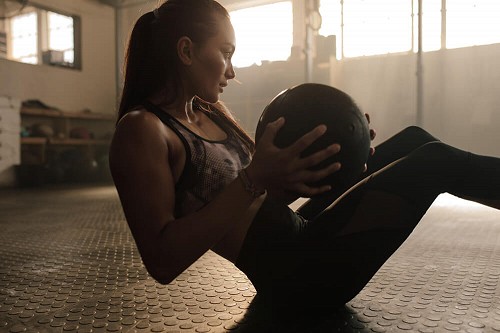 A woman doing exercise with a medicine ball